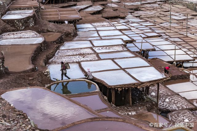 图为盐民在晒盐.